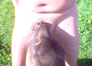 Outdoorsy mendicant with a flabby belly sucked by a dog